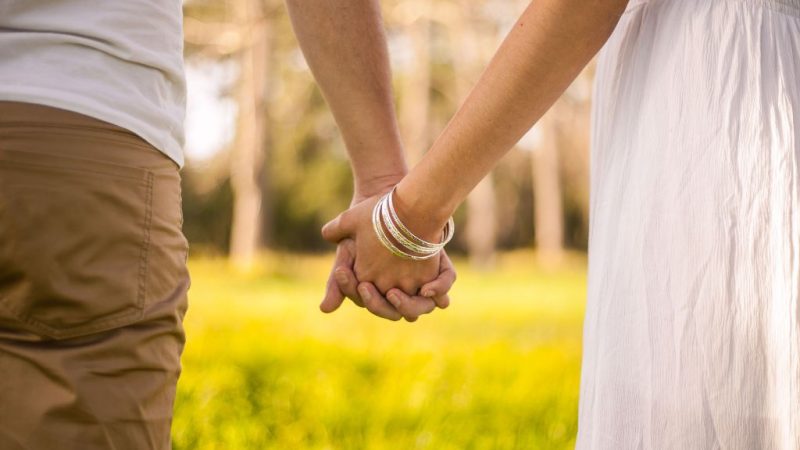 Щастлива двойка се разхожда ръка за ръка, наслаждавайки се на романтична почивка